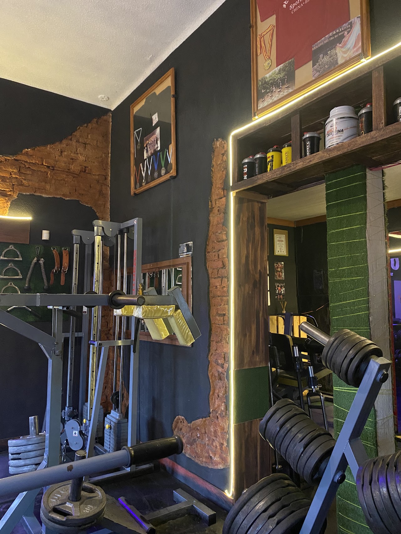 Sala de musculación del Centro de Entrenamiento Muscular en Berazategui, con máquina de poleas y ambientación premium