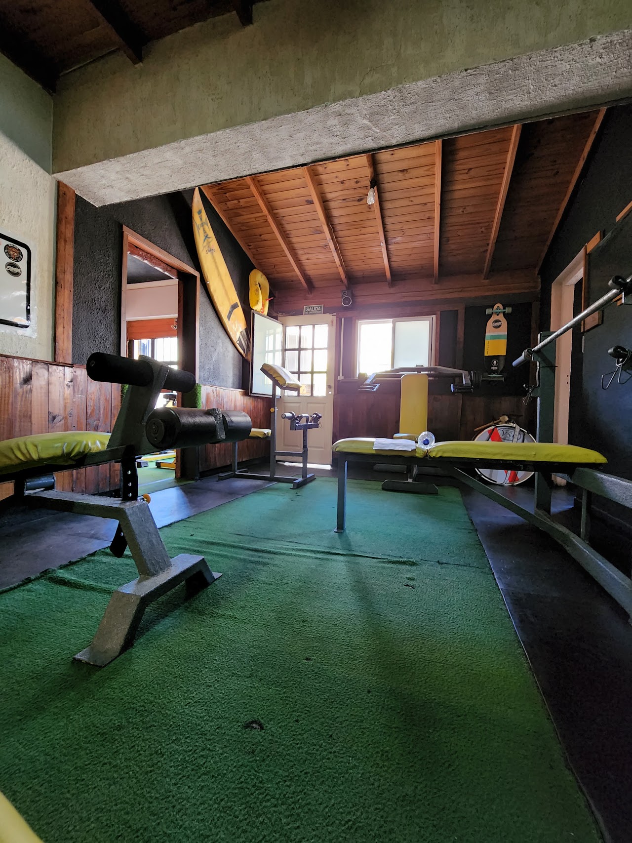 Zona de bancos y pesos del Centro de Entrenamiento Muscular, ambientación de madera